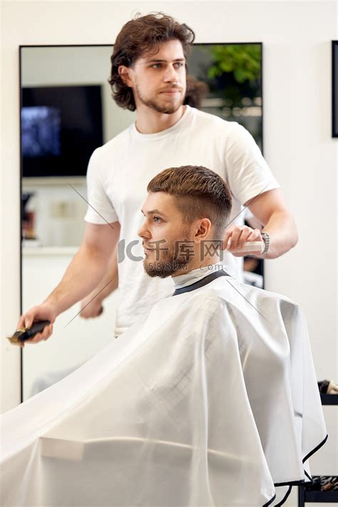 在理发店拜访专业发型师的男士高清摄影大图-千库网