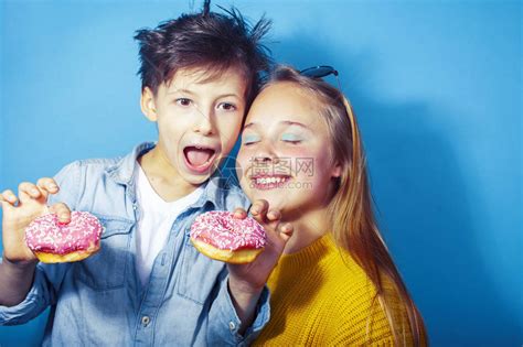 幸福的家庭兄弟姐妹吃蓝色背景的甜圈高清图片下载-正版图片506108887-摄图网