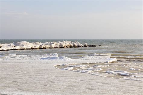 Premium Photo | Closeup of the icy seashore frozen waves rocks and sun ...