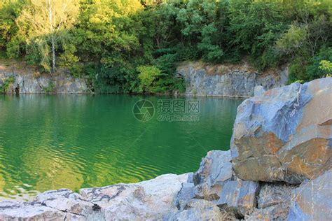 夏季的高山湖泊用氡水淹没旧花岗岩采石场的全景与石块绿树和干净高清图片下载-正版图片506688037-摄图网