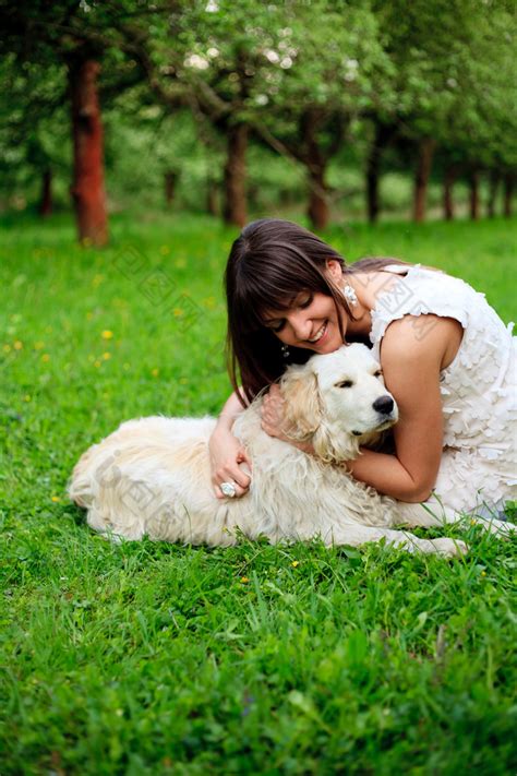 草地上抱着狗的女人图片-包图网
