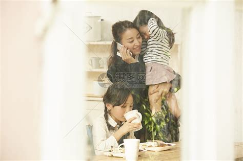 妈妈打电话抱着吃午餐的姐妹俩高清图片下载-正版图片502174412-摄图网