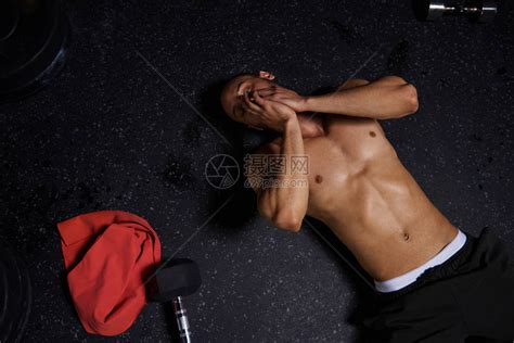 男精疲力竭的运动员躺在健身房地板高清图片下载-正版图片507369276-摄图网