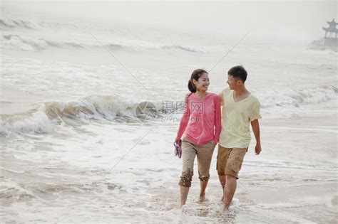 年轻夫妇走在海滩上的水边高清图片下载-正版图片507115361-摄图网