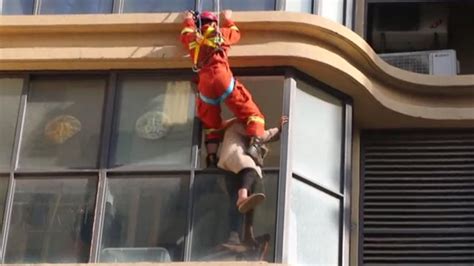 女子骑坐5楼窗台痛哭欲跳楼 消防员从天而降将其一脚踹回_新浪新闻