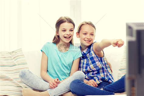 人,孩子,电视,朋友友谊的两个快乐的小女孩家里看电视指指点点高清图片下载-正版图片300591953-摄图网