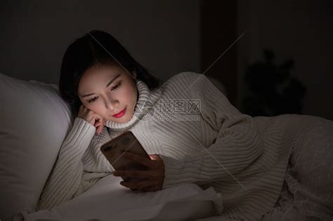 女生躺着玩手机图片