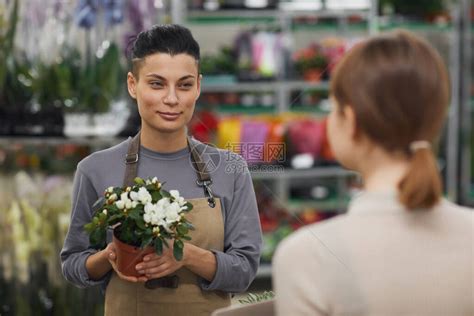 在花店里卖鲜花给顾客高清图片下载-正版图片506483170-摄图网