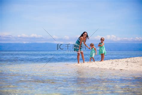 可爱的小女孩和年轻妈妈在荒岛的热带白色沙滩上玩得开心高清摄影大图-千库网