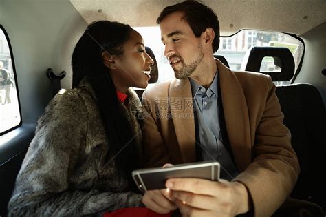 坐在出租车后面的一对情侣相视而笑高清图片下载-正版图片501861686-摄图网