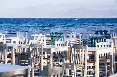 海边餐厅的桌子上放着沙拉和一杯白葡萄酒高清摄影大图-千库网