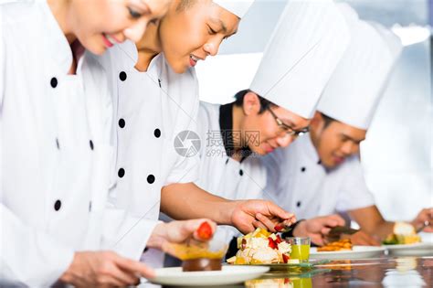 亚裔印度尼西亚厨师和其他厨师一起在餐馆或旅馆做饭烹饪最后菜高清图片下载-正版图片504881470-摄图网