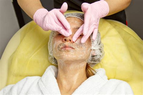 概念美容师美容师的手把奶油涂在女人的脸上美容师将奶油涂高清图片下载-正版图片506278650-摄图网