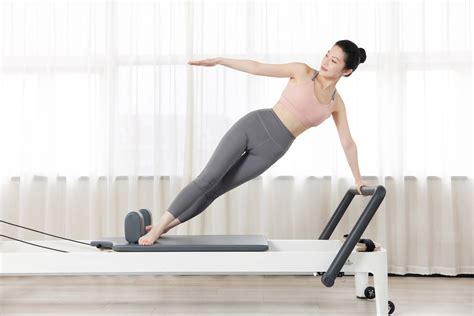 普拉提伸展运动在重整床上健身房女人图片-包图网企业站
