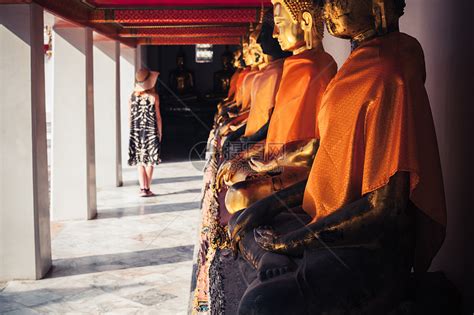 一个年轻的女人正看寺庙里的排佛像高清图片下载-正版图片300680772-摄图网