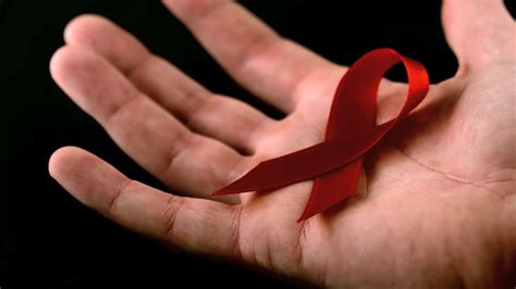艾滋病红丝带标志落在一个男人的手上视频素材_ID:VCG42N500525205-VCG.COM