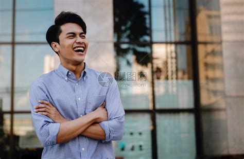激励时髦的男笑亚裔青年商人在城市横跨双臂的肖像望着一个快乐的友善人高清图片下载-正版图片307725471-摄图网