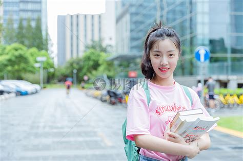 大学校园内女生抱着书本高清图片下载-正版图片500625620-摄图网