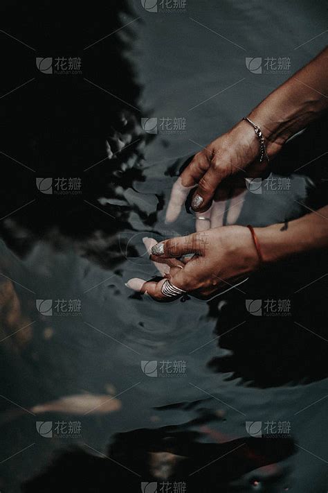 女人的手在池塘的黑水里