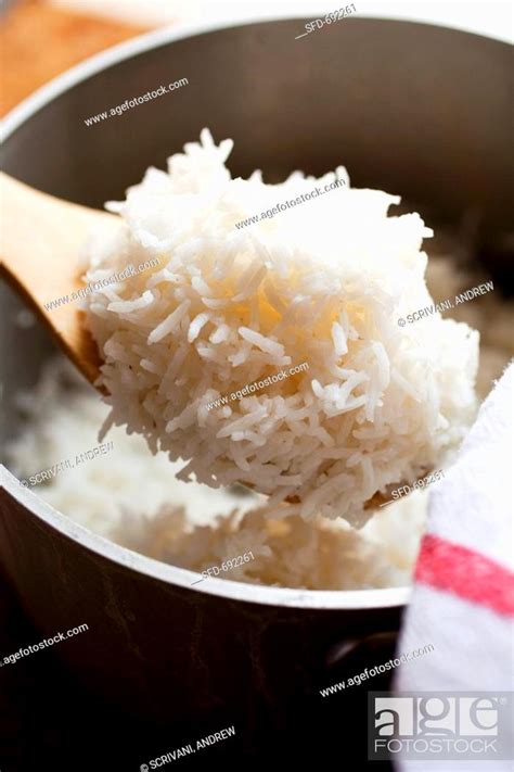 Wooden Spoonful of White Rice Over Pot of Rice, Stock Photo, Picture ...