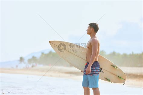 年轻男士拿着冲浪板海边行走高清图片下载-正版图片501743562-摄图网