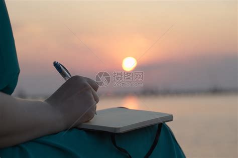 一个女人在日落时在日记中写字的特写镜头高清图片下载-正版图片503211871-摄图网
