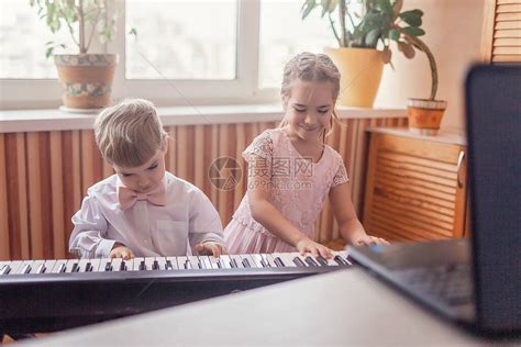 两位年轻音乐家在线音乐会期间在家演奏经典数码钢琴隔离期间的社交距离自我隔离在线教高清图片下载-正版图片506514281-摄图网