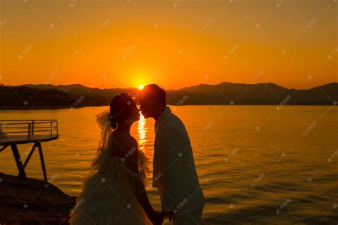 夕阳婚纱照剪影两个人户外亲吻摄影图配图高清摄影大图-千库网