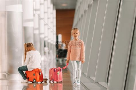 在大国际机场的可爱小女孩准备度假舒适小女孩在机场玩得开心坐在行李箱上等登机等待登机的好女孩手提箱飞机场高清图片下载-正版图片307994458-摄图网