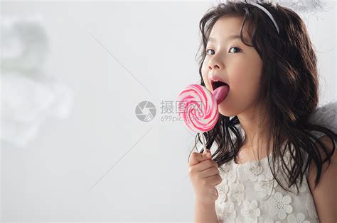 户内欢乐休闲装吃棒棒糖的可爱小女孩高清图片下载-正版图片501906267-摄图网
