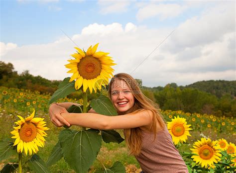在田里拥抱向日葵的少女高清图片下载-正版图片501447093-摄图网