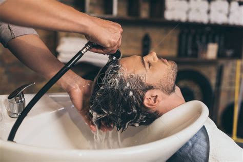 发型师在理发店给客户洗头发高清图片下载-正版图片502662326-摄图网