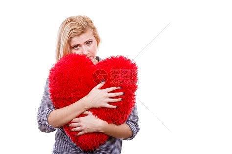 情人节,浪漫关系符号的快乐悲伤的轻女人抱着红色的大枕头,心形伤心的女孩抱着红色的大枕头高清图片下载-正版图片300887724-摄图网