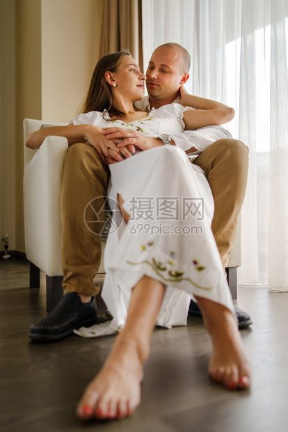 快乐的相信年轻男女夫妻相爱在蜜月时坐椅子上握着手亲吻对方的情侣和丈夫与妻子在约会情怀高清图片下载-正版图片308022045-摄图网