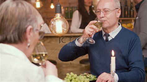 六十多岁的夫妇在餐厅吃午饭时喝酒高清摄影大图-千库网