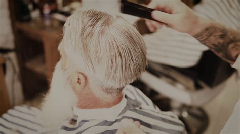 理发师正在为一个英俊的白发老人做时髦的发型视频素材_ID:VCG42N1399522874-VCG.COM