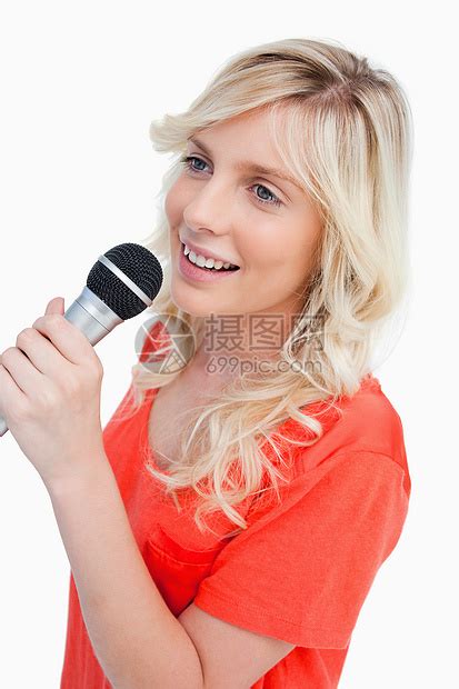 微笑的女人用麦克风歌唱高清图片下载-正版图片321407336-摄图网