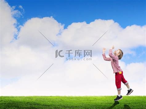 无忧无虑的小男孩户外拥抱草坪上的天空高清图片下载-正版图片300467809-摄图网