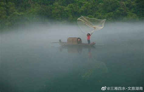 湖南小东江，云雾萦绕山间，一叶小舟飘在江面，静如止水……
