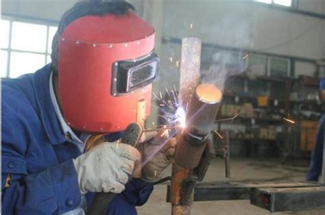 熟练的焊工戴着面具在车间进行焊接。在焊接过程中，铁棒上有很多火花。照片摄影图片_ID:433748463-Veer图库