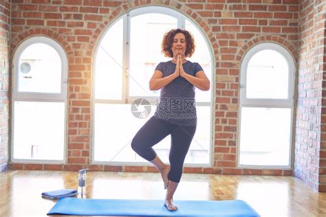 站在床上练瑜伽在健身房做树上姿势的垫高清图片下载-正版图片504499132-摄图网