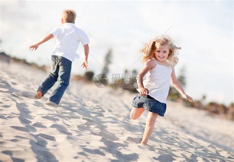可爱的金发兄妹两人一起在沙滩上玩的很开心高清图片下载-正版图片502517334-摄图网