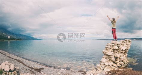 女孩双手举起站在一堆石头上高清图片下载-正版图片506257025-摄图网