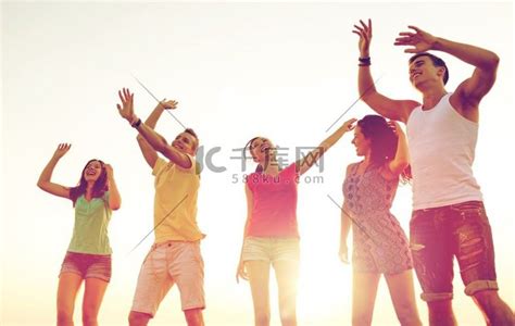 友谊、暑假、假期、聚会和人的概念-一群微笑的朋友在沙滩上跳舞。高清摄影大图-千库网