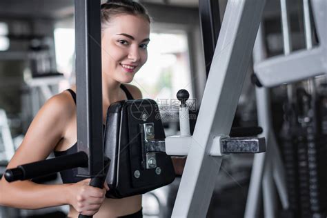 年轻有吸引力的健身女子在健身房里用机器锻高清图片下载-正版图片504510171-摄图网