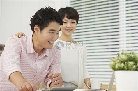 夫妻二人看笔记本电脑十分开心高清图片下载-正版图片502121053-摄图网