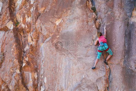 一个女孩爬上岩石运动员在大自然中训练女人克服了艰难的攀登路线强壮的登山者极端的爱好高清图片下载-正版图片506447915-摄图网