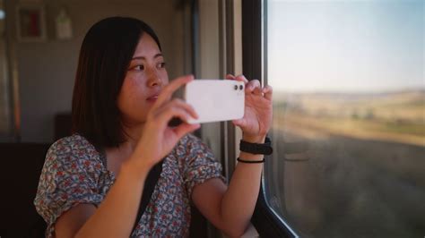 年轻的女游客乘火车旅行，通过窗口用手机拍照和录像—高清视频下载、购买_视觉中国视频素材中心