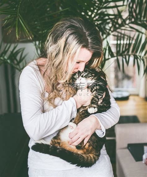 客厅里的漂亮女人把猫抱在怀里拥抱人物特写时装T台高清摄影大图-千库网