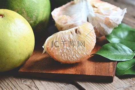 木板背景上的柚子果、新鲜的绿色柚子去皮和叶子来自柚子树、柚子、泰国夏季热带水果中的柚子高清摄影大图-千库网